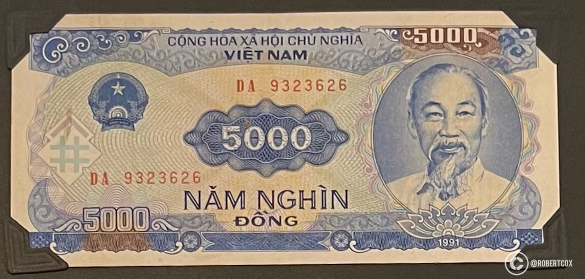 5,000 Vietnamese đồng banknote from the Socialist Republic of Vietnam, issued in 1991. The note features the national emblem of Vietnam on the left side, which includes a star, rice, and a cogwheel, symbolizing agriculture and industry. The portrait on the right is of Hồ Chí Minh.