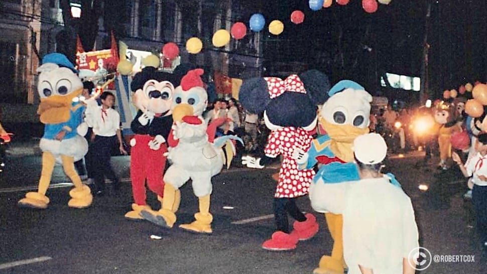 A group of participants in colorful mascot costumes resembling characters like Mickey Mouse, Minnie Mouse, Donald Duck, and a rooster, at the parade rehearsal on April 28, 1995.